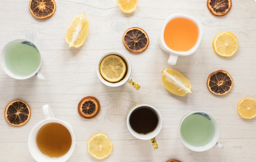 4 tasses de thé vues de dessus à coté de fruits séchés