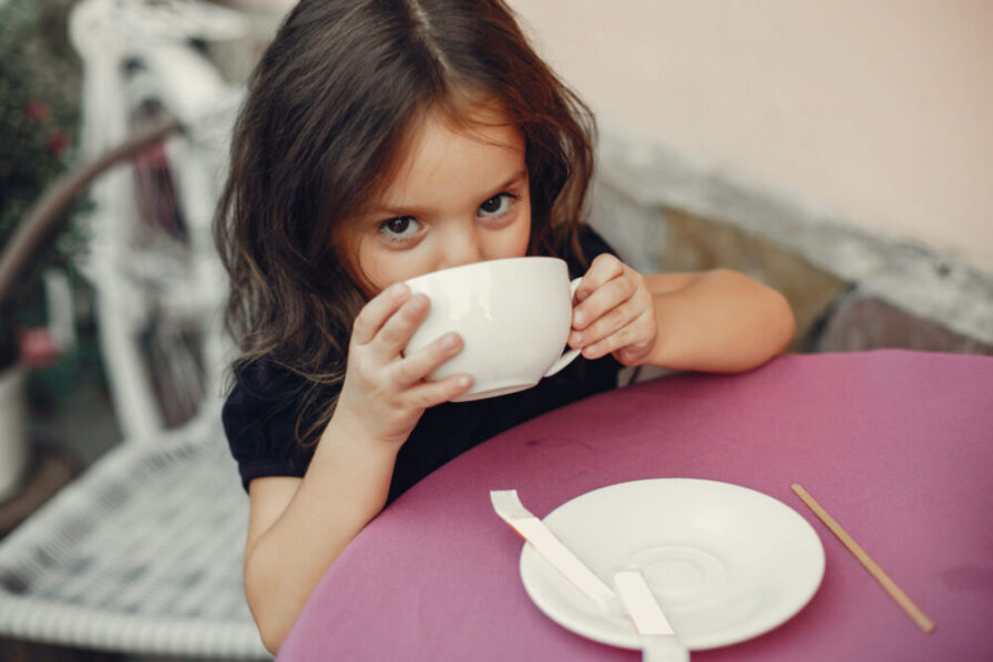 Jeune fille buvant un thé dans une grande tasse blanche